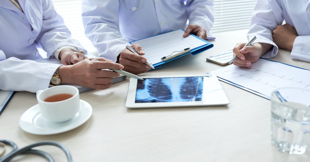 Doctors discussing chest x-ray on tablet computer